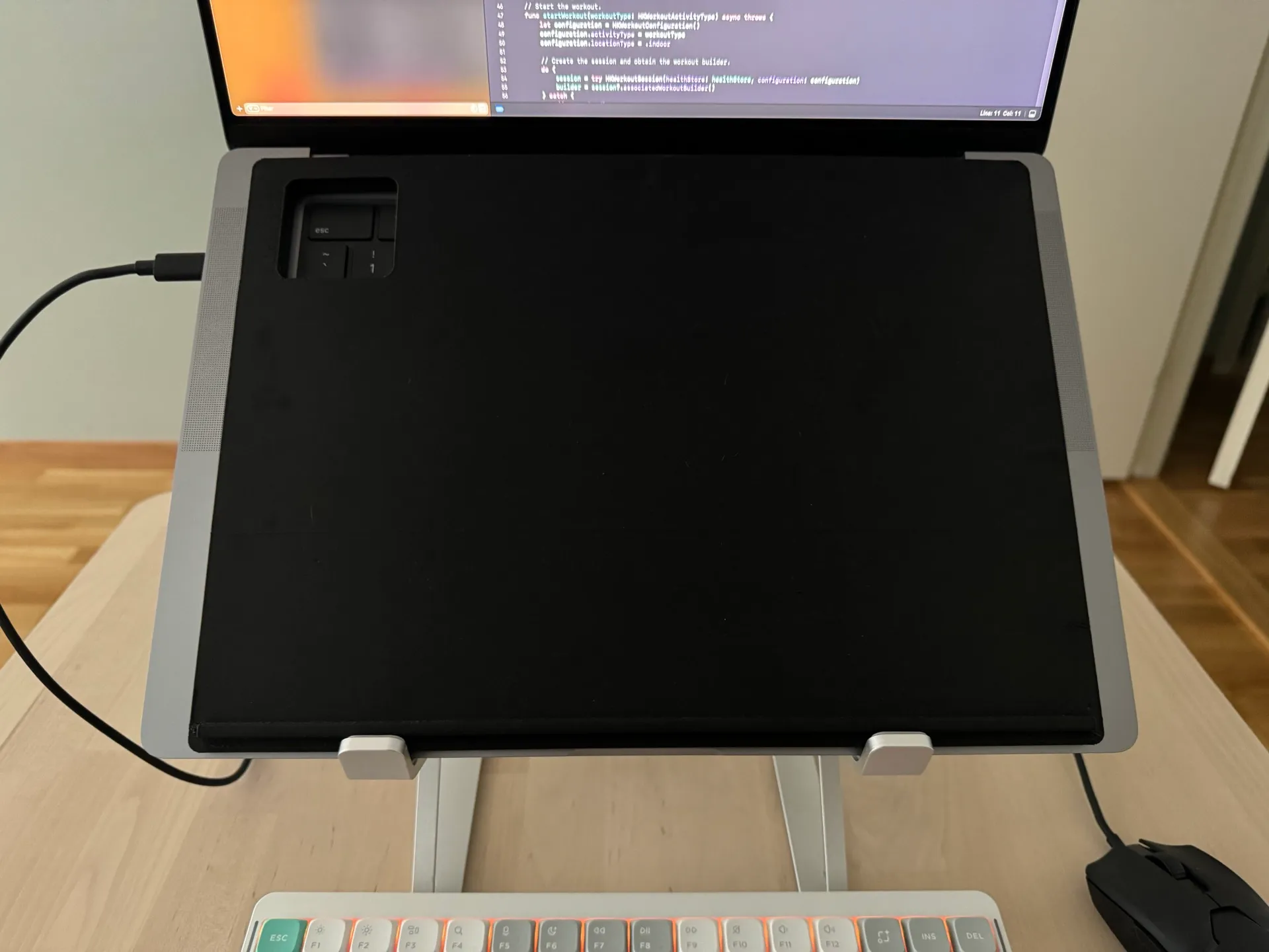 Close-up of the iPad sitting on the tray over the MacBook keyboard