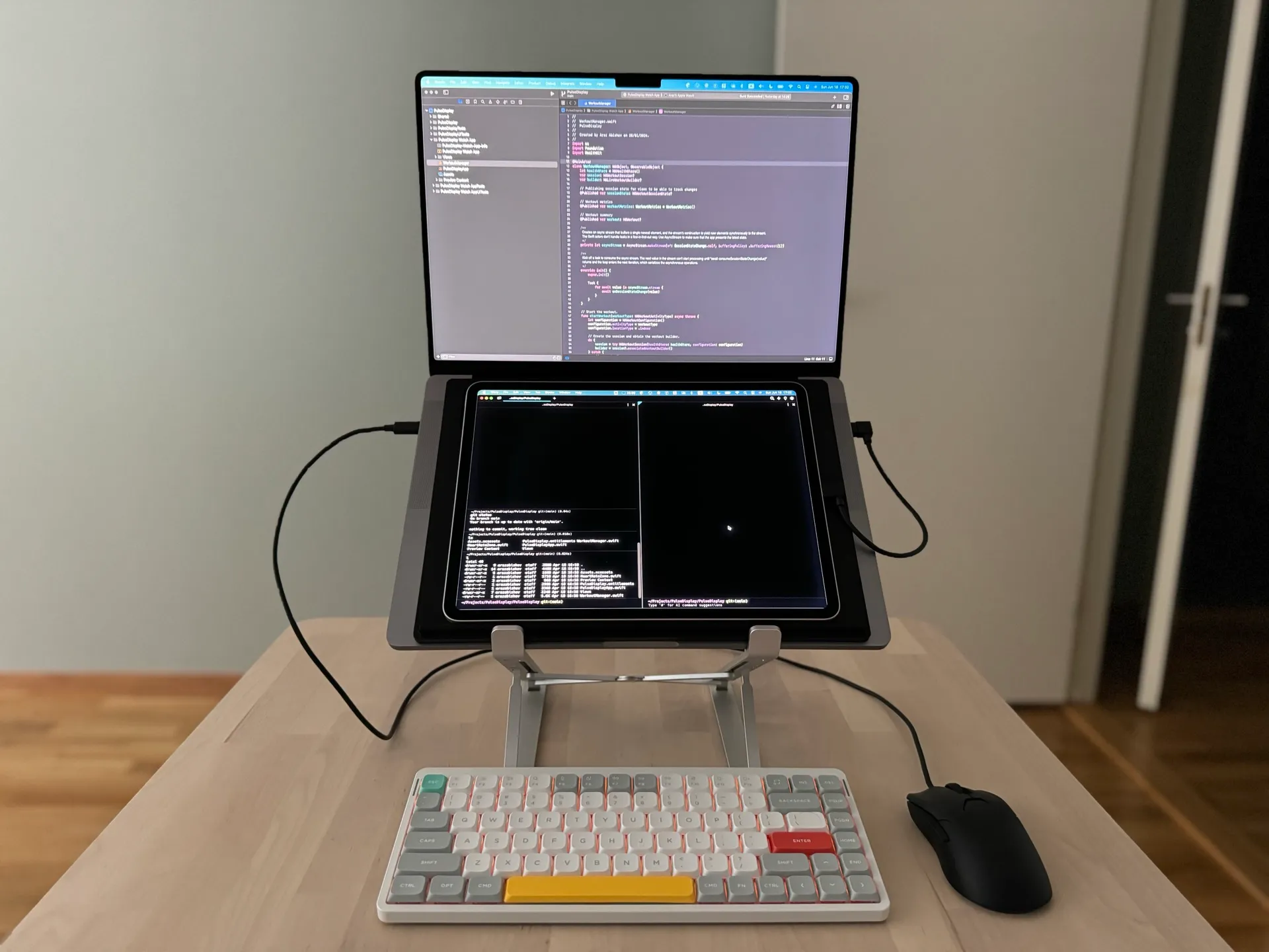 The full setup with MacBook Pro on a stand, iPad as a second display, external keyboard and mouse